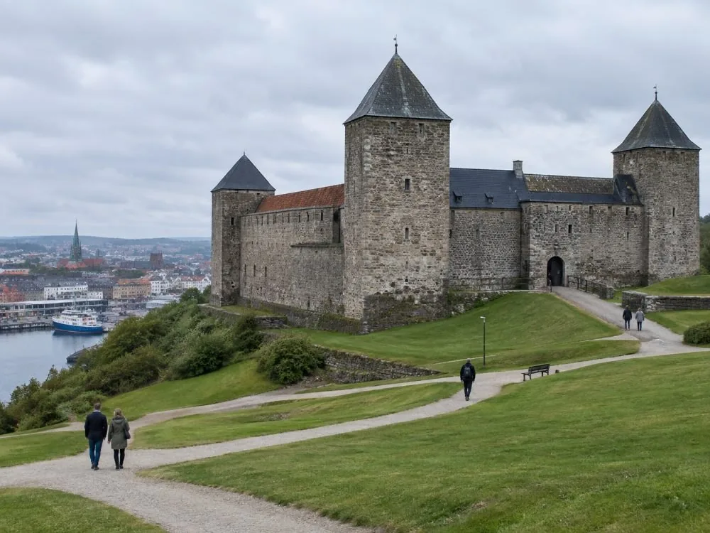 Die Festung Akershus über dem Hafen: dicke Steinmauern und Türme auf einem grünen Ufer, mit den Kieswegen des Geländes, durch die jede Stadtrundführung führt.