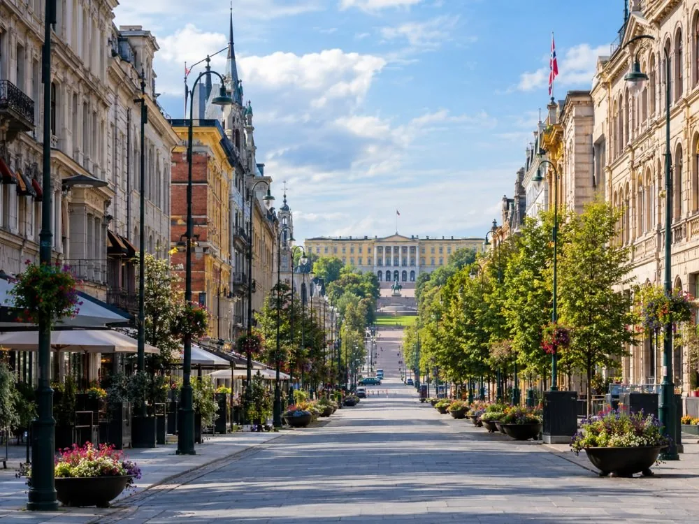 Karl Johans gate, die Hauptstraße, die 1852 benannt wurde, mit Blick entlang der breiten Gehfläche zwischen ihren Gebäuden zum ansteigenden Gelände am Palastende.